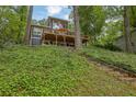 Contemporary two-story home with a spacious deck, surrounded by lush greenery with stone steps leading to the house at 132 Lakeshore Dr, Roswell, GA 30075