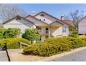 Beige two-story home featuring a charming balcony, chimney, and well-maintained landscaping at 207 Bridge Se Ln, Smyrna, GA 30082