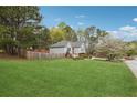 Large green backyard featuring a fenced perimeter, mature trees, and a charming home exterior at 21 Enclave Walk, Powder Springs, GA 30127