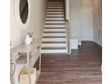 Welcoming entryway featuring wood floors, staircase, console table, and modern decor accents at 308 Overture Ct, Smyrna, GA 30080