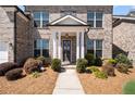 Inviting entryway with a decorative wreath and well-landscaped bushes at 11620 Crestview Ter, Johns Creek, GA 30024