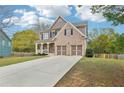 Attractive home with a two-car garage, brick accents, and a cozy front porch at 105 Oakfield Way, Douglasville, GA 30134
