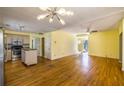 Open-concept kitchen with stainless steel appliances, island, yellow walls, and wood floors at 4186 Argonne Dr, Villa Rica, GA 30180