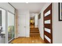 Bright entryway with modern wood door, hardwood floors, and access to a patio through sliding glass doors at 240 W Spalding Dr, Sandy Springs, GA 30328