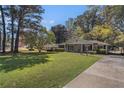 Traditional single-story home with a well-manicured lawn and a covered front porch, complemented by mature trees at 2992 Westminster Nw Cir, Atlanta, GA 30327