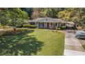 Traditional single-story home with a well-manicured lawn and a covered front porch, complemented by mature trees at 2992 Westminster Nw Cir, Atlanta, GA 30327