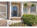 Inviting front entrance with brick steps, black-framed door, decorative lanterns, and lush landscaping at 3225 Suffolk Dr, Cumming, GA 30041