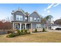 Beautifully landscaped front yard leading to a charming two-story home featuring gray siding and a cozy front porch at 29 Laurelwood Nw Ln, Cartersville, GA 30121