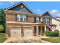 Charming two-story brick home with a two-car garage, porch and an American flag at 346 M J Mccarthy Way, Hampton, GA 30228