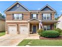 Inviting two-story brick home with a manicured lawn and a charming covered front porch at 346 M J Mccarthy Way, Hampton, GA 30228