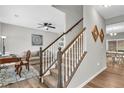 Elegant staircase with wood railings, carpeted steps, and views of the living and dining areas at 6350 Lantana Village Way, Cumming, GA 30028