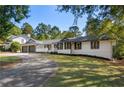 Lovely single-story home showcasing a gray and white color scheme, with mature trees at 1025 Martins Lake Close, Roswell, GA 30076