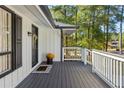 Welcoming front porch with white railings and a charming entrance with black door at 1025 Martins Lake Close, Roswell, GA 30076