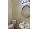 A simple powder room features a pedestal sink with an oval mirror and a standard toilet in a neutral color scheme at 3259 S Pointe Ct, Atlanta, GA 30340