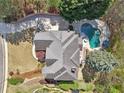 Aerial view of a well-maintained home with a pool, a meticulously designed backyard, and lush landscaping at 4215 Homestead Ridge Dr, Cumming, GA 30041