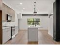 View of a modern open concept kitchen with white cabinets, island and stainless steel appliances at 108 Park Place Unit 104, Decatur, GA 30030
