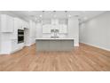 Bright, modern kitchen featuring a large island, white cabinets, and stainless steel appliances at 2572 Silver Star Ne Dr, Marietta, GA 30066