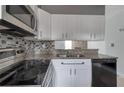 Modern kitchen featuring stainless steel appliances, granite counters, and stylish backsplash at 6691 Colchester Pl, Norcross, GA 30093