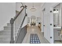 Open foyer with high ceilings, staircase, chandelier and luxury vinyl plank flooring at 1055 Crabapple Parc Dr, Roswell, GA 30076