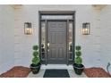 Close up of the front door with sidelights, plants and updated hardware at 1055 Crabapple Parc Dr, Roswell, GA 30076