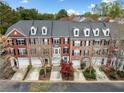 Aerial view of brick townhomes with garages, dormer windows, mature trees, and manicured landscaping at 4908 Waters Edge Trl, Roswell, GA 30075