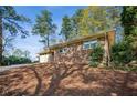 Brick home featuring a carport and a front yard covered in pine straw at 3712 Spring Hill Se Rd, Smyrna, GA 30080