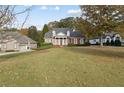 Beautiful brick home with stately columns, lush landscaping, and a sprawling green lawn surrounded by mature trees at 4385 Old Hamilton Mill Rd, Buford, GA 30518