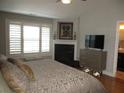 Inviting main bedroom featuring a fireplace, window with shutters, and a comfortable king-size bed at 11 Reese Way # 11, Avondale Estates, GA 30002
