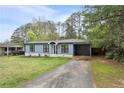 Inviting home with light blue siding, black trim, driveway, and an attached carport at 1601 Sycamore Nw Dr, Kennesaw, GA 30152