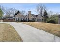 View of the home featuring a wide driveway and a landscaped yard in a well-maintained neighborhood at 2973 Heavenly Ln, Snellville, GA 30078
