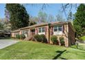 Side view of a single-story brick home with green grass and mature trees at 2223 Jay Se Ln, Smyrna, GA 30080