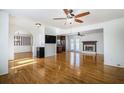 Open living room with hardwood floors, fireplace, ceiling fan, and view to dining and kitchen at 2223 Jay Se Ln, Smyrna, GA 30080