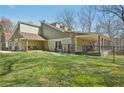 Well-kept green lawn in back with covered patio and a black chain-link fence at 302 Vinson Mountain Loop, Rockmart, GA 30153