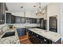 Modern kitchen with granite countertops, stainless steel appliances, and black cabinets at 302 Vinson Mountain Loop, Rockmart, GA 30153