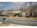 A line of brick townhouses with black shutters, landscaping, and visible street address at 5980 Eagle Tiff Ln, Sugar Hill, GA 30518