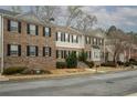 Row of townhouses featuring a combination of brick and gray siding, complemented by lush landscaping at 5980 Eagle Tiff Ln, Sugar Hill, GA 30518