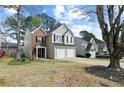 Well-kept home with a brick facade, complemented by a two-car garage and lush trees at 4248 Brighton Nw Way, Kennesaw, GA 30144