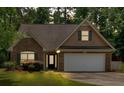 Beautiful home boasts a brick facade, attached two-car garage, and manicured front yard at 8166 N Pine Cone Dr, Villa Rica, GA 30180