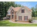 Beautiful home with lush green lawn, stone accents, brick red shutters, and an attached garage at 241 Rose Ridge Dr, Canton, GA 30115