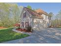Attached three car garage with concrete driveway and manicured landscaping surrounding the home at 241 Rose Ridge Dr, Canton, GA 30115