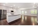 Modern kitchen with stainless steel appliances, island with sink, and open to the living area at 400 Paulownia Cir, Mcdonough, GA 30253