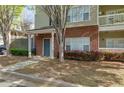 Inviting brick entrance of townhouse with manicured garden and covered entry at 8020 Woodland Ln, Alpharetta, GA 30009