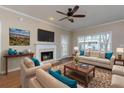 Bright living room featuring a cozy fireplace, large window, and stylish furniture at 8020 Woodland Ln, Alpharetta, GA 30009