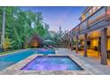 Resort-style pool and spa with stone accents, complemented by an outdoor kitchen and covered patio at 1438 Kings Park Nw Dr, Kennesaw, GA 30152