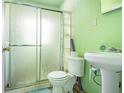 Compact bathroom featuring a sliding glass shower door and simple fixtures at 854 Slaton St, Forest Park, GA 30297