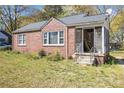 A cozy brick home showcasing a screened front porch, complemented by lush lawn at 854 Slaton St, Forest Park, GA 30297