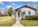 Charming white brick home with inviting walkway lighting and well-maintained lawn at 1780 John Calvin Ave, Atlanta, GA 30337