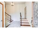 Bright foyer with stairs leading up and down, featuring tile flooring and decorative glass at 4983 Odins Way, Marietta, GA 30068