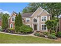 Stately two-story home with lush landscaping and a welcoming walkway at 12350 Edenwilde Dr, Roswell, GA 30075
