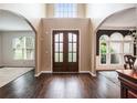 Grand foyer featuring dark wood floors, an elegant double door entrance, and arched doorways at 12350 Edenwilde Dr, Roswell, GA 30075